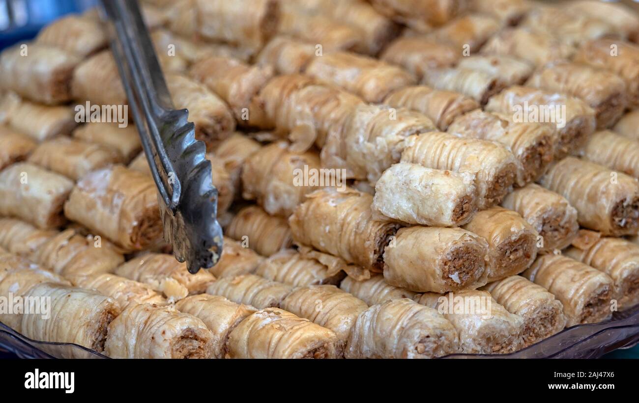 Baklava and serving tongs on a bakery stall at a Food market Stock Photo