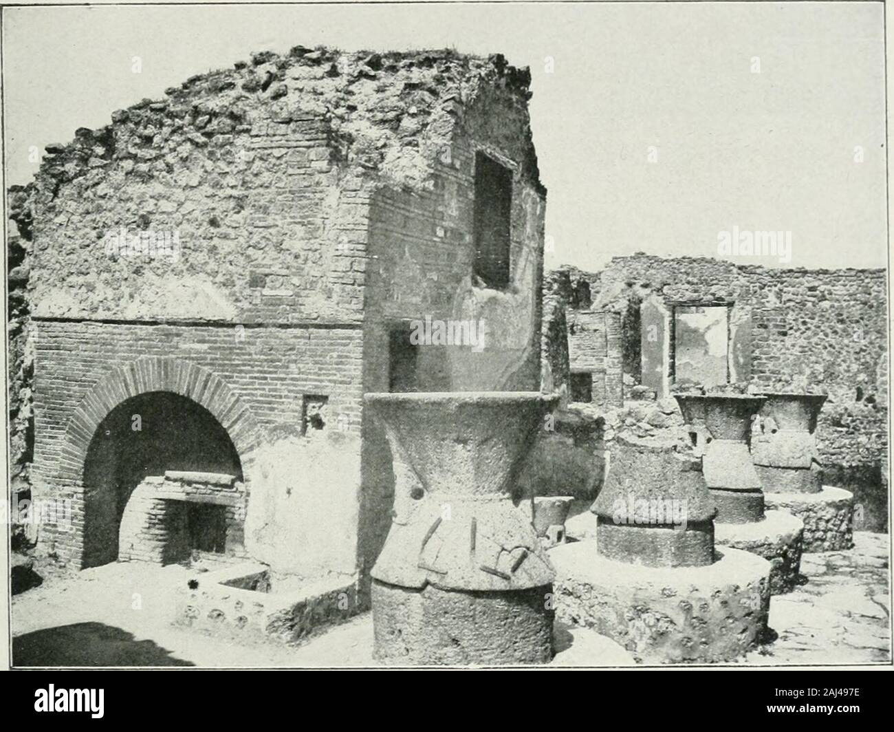 Pompéi : vie publique . le moulage dune de ces clôtures. La rainure usée oubrisée était racommodée avec une barre en fer. Les auberges étaient assez nombreuses à Pompéi. Celle qui portaitlenseigne de Téléphant avait un triclinium avec trois lits, et une installa-tion commode, du moins Taffiche le disait i^VII, i, 451. Non loin de là;VII, II, II) une autre auberge, beaucoup plus grande a, dans un vastejardin, des cabinets particuliers. Dans une auberge de la même région LES CABARETS, LES BOUTIQUES, LES METIERS (VII, 12, 35), des voN^ageurs ont écrit sur les murs la mention de leurpassage et que Stock Photo