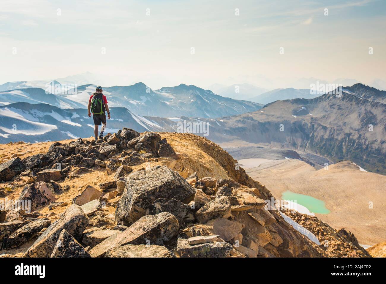 Backpacker hiking on mountain summit. Stock Photo