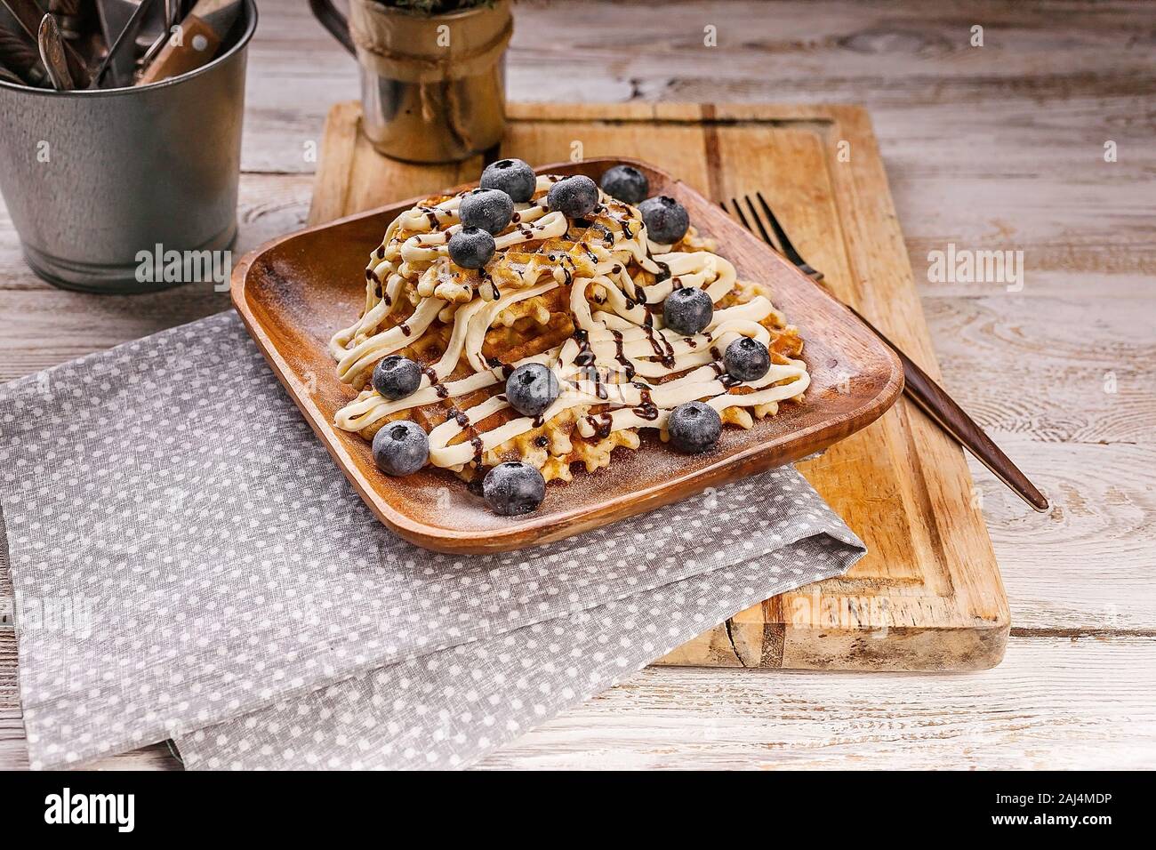 Waffles with butter cream, chocolate and blueberries. Sweet dessert. Homemade baking. Stock Photo
