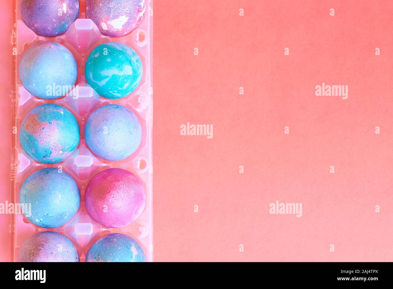 Painted Easter eggs with space intergalactic pattern in stand on coral background Stock Photo