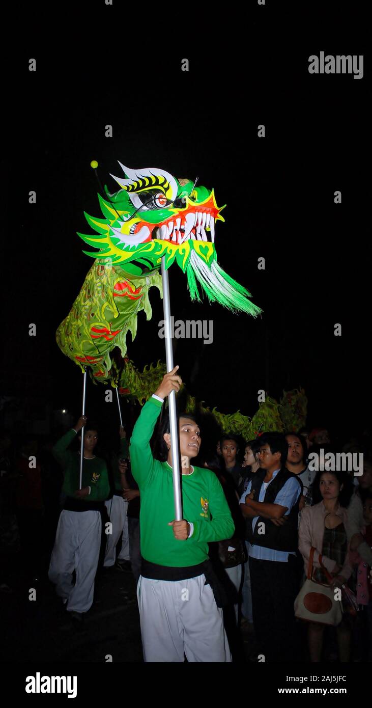 A dragon puppet is played with stick in Chinese New year celebration festival. Stock Photo