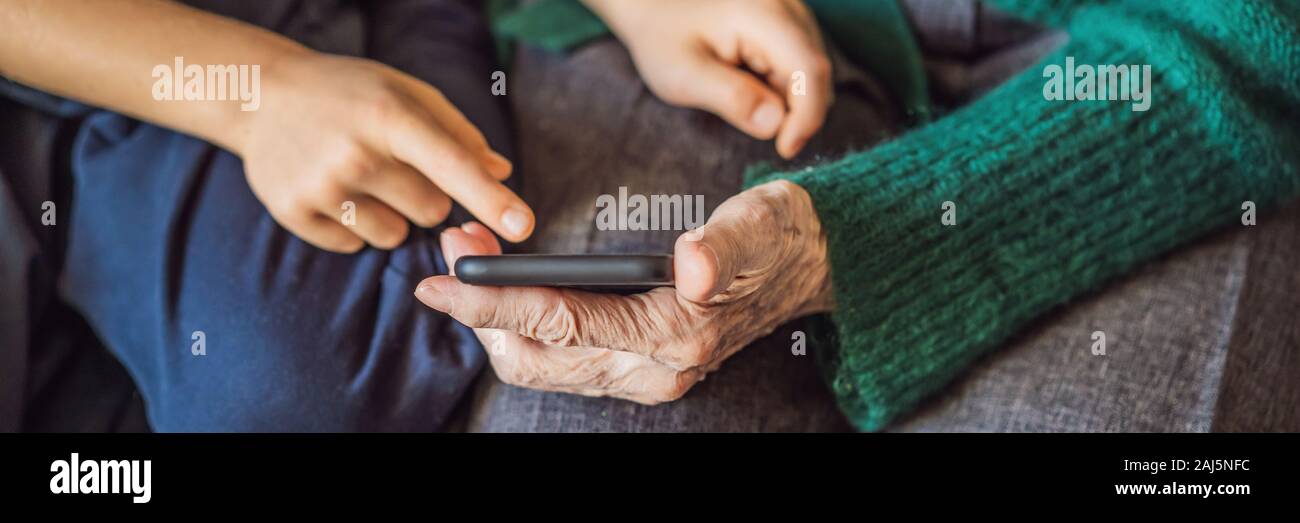 Grandmother and grandson are looking at a smartphone BANNER, LONG FORMAT Stock Photo