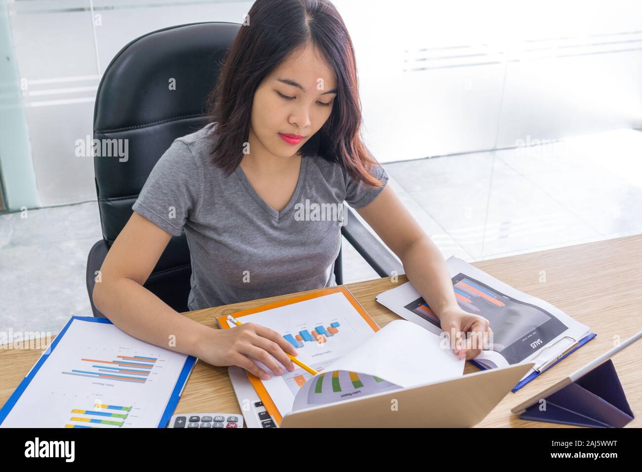 Office lady analyzing graphs on sales reports Stock Photo