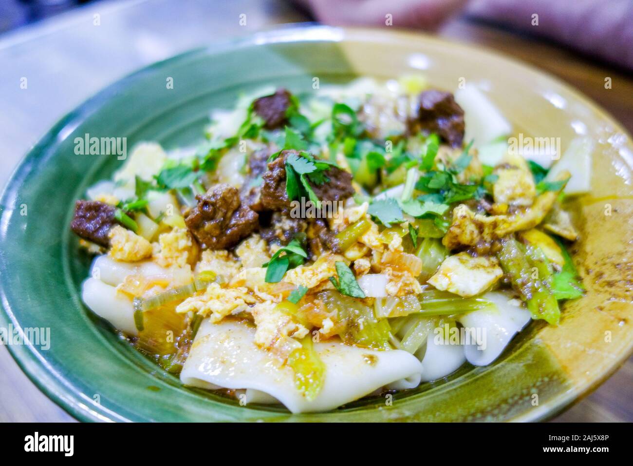 A bowl of biang biang mian noodles, a famous dish from the city of Xi'an, at the Muslim street night market in Xian, in the Shaanxi province of China Stock Photo
