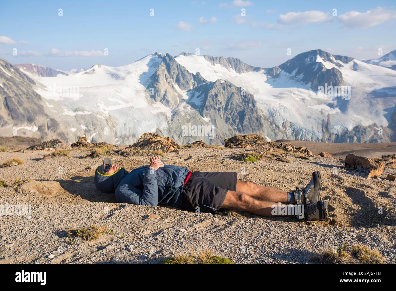 Hiker lying on mountain summit, exhausted after a long day Stock Photo