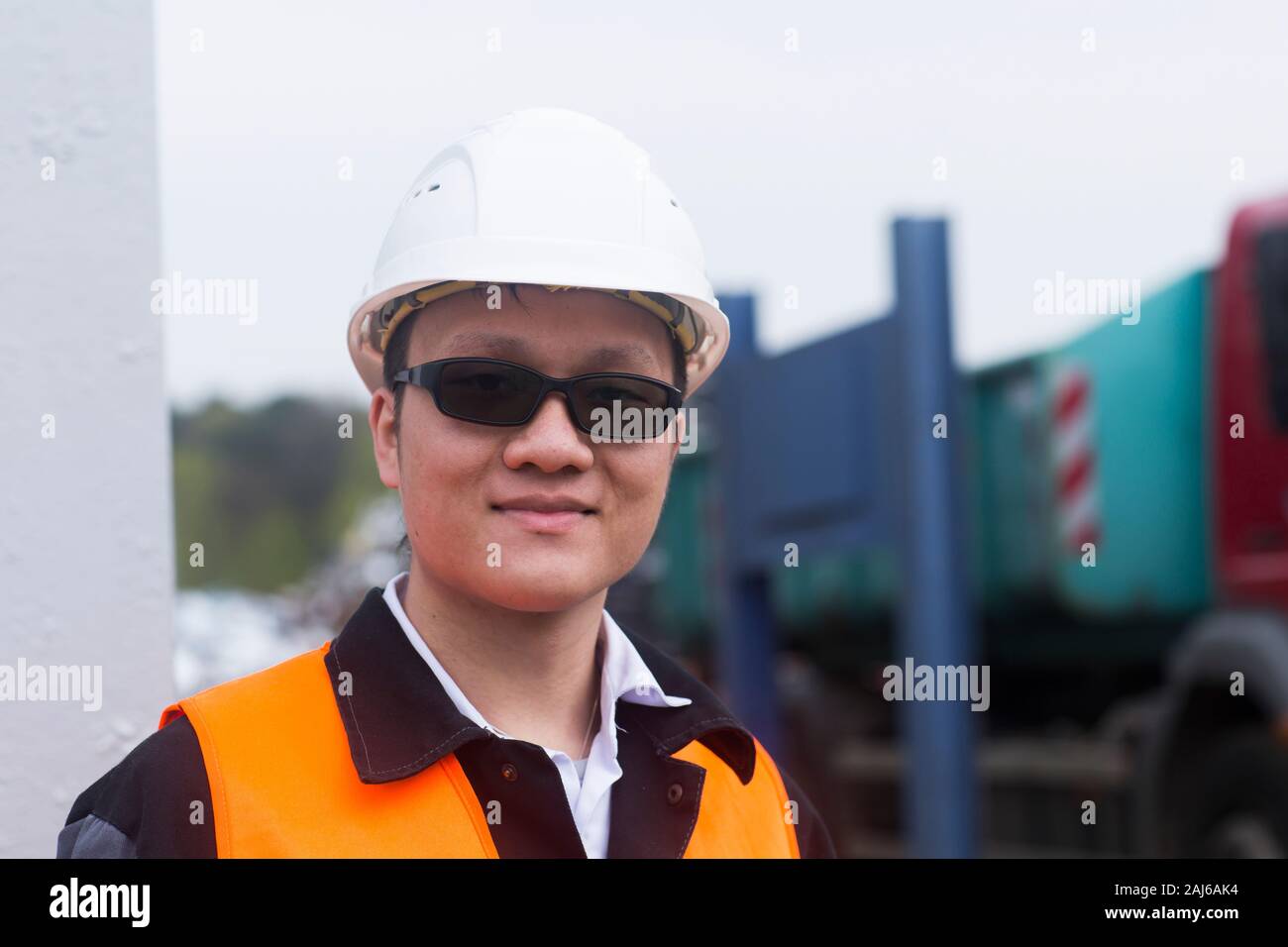 worker outside looking  in front of containers Stock Photo