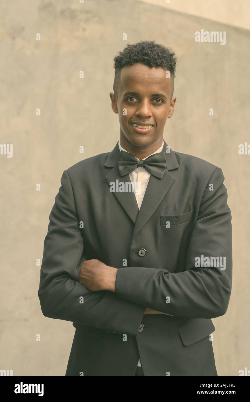 Portrait of young handsome African businessman wearing suit against ...