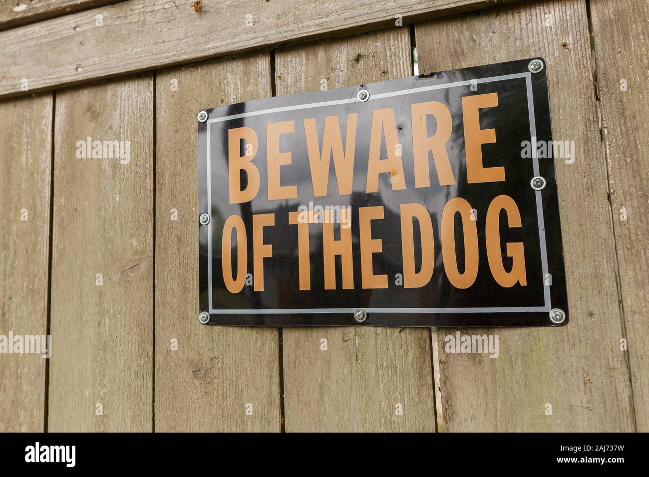 Beware of the Dog Warning Sign on the Wooden Fence Stock Photo