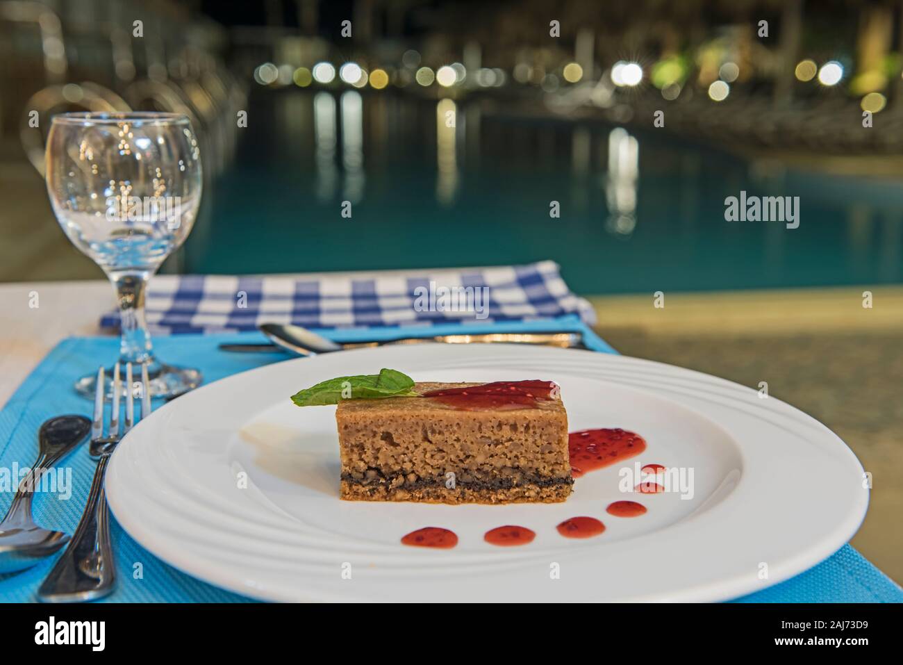 Chocolate sponge cake dessert food at luxury a la carte restaurant by swimming pool with sauce Stock Photo