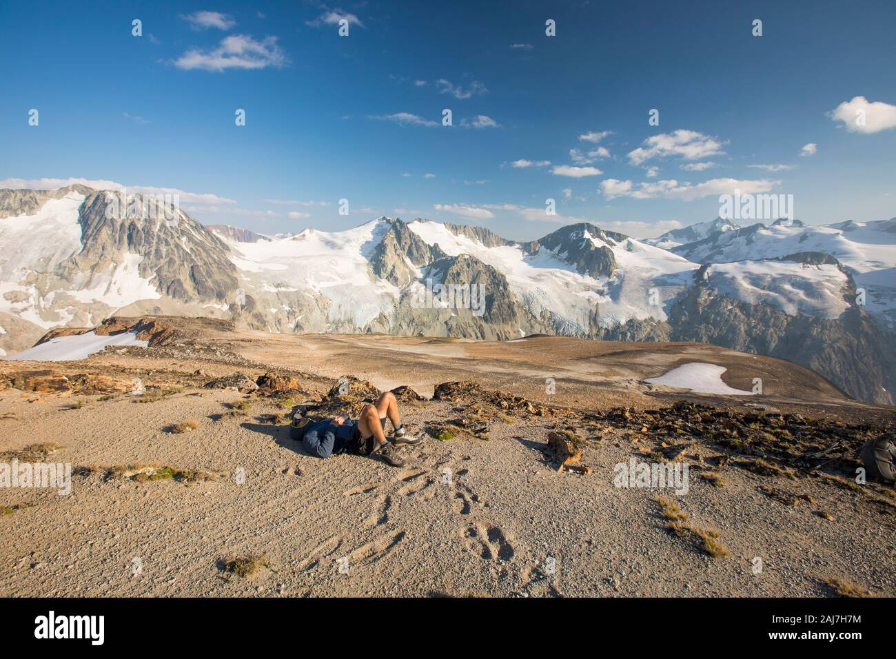 Hiker lying on mountain summit, exhausted after a long day Stock Photo