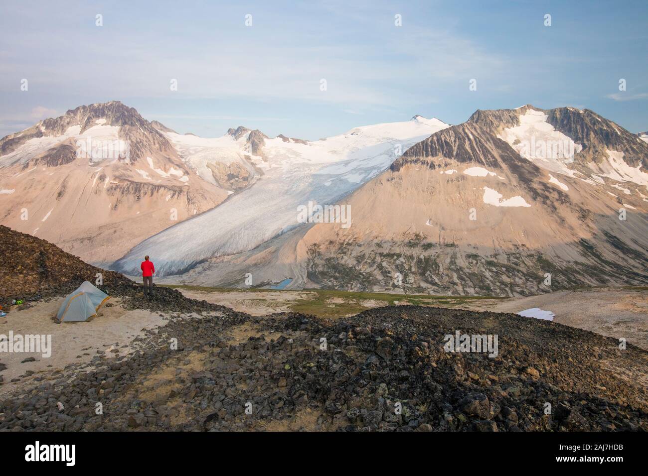 Hiker camping on mountain summit. Stock Photo