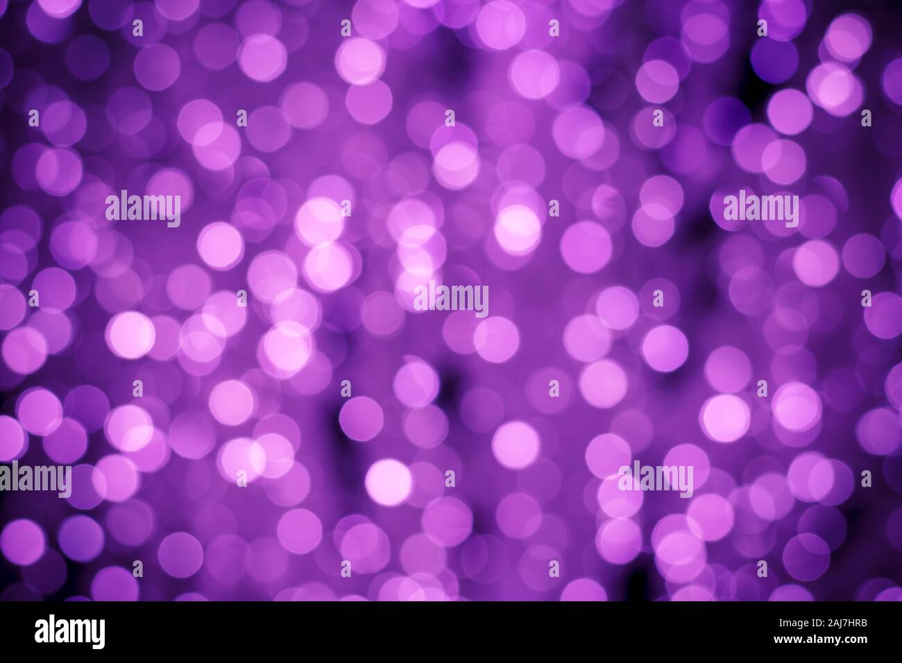 Abstract purple background with night bokeh lights. Illuminated backgrounds. Blurred backdrop, glowing texture, defocused boke. Shiny pink circles. Gl Stock Photo