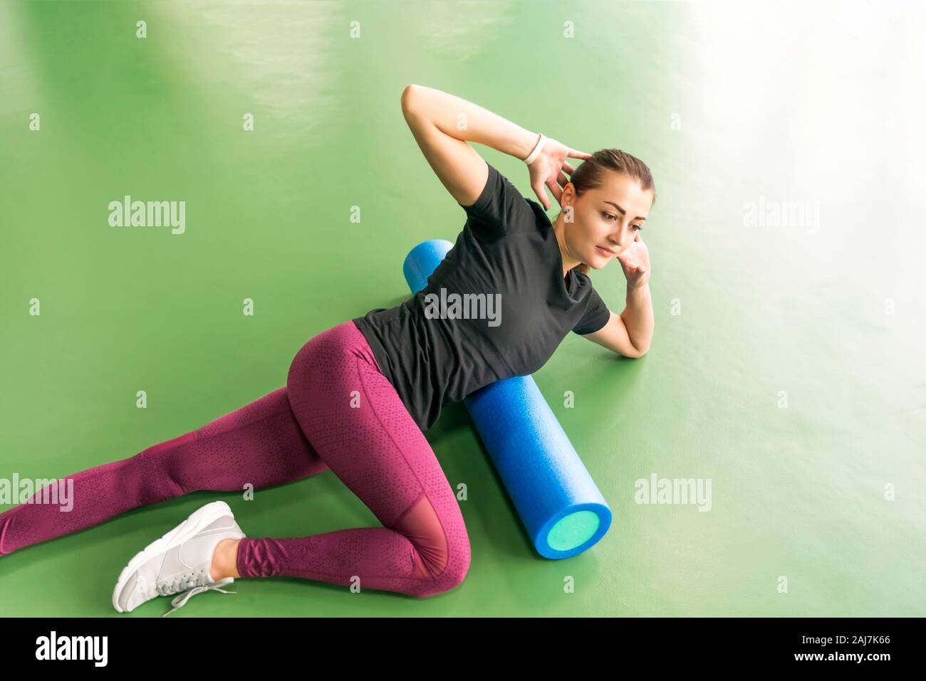 Woman doing foam roller exercise on a floor in gym Stock Photo - Alamy