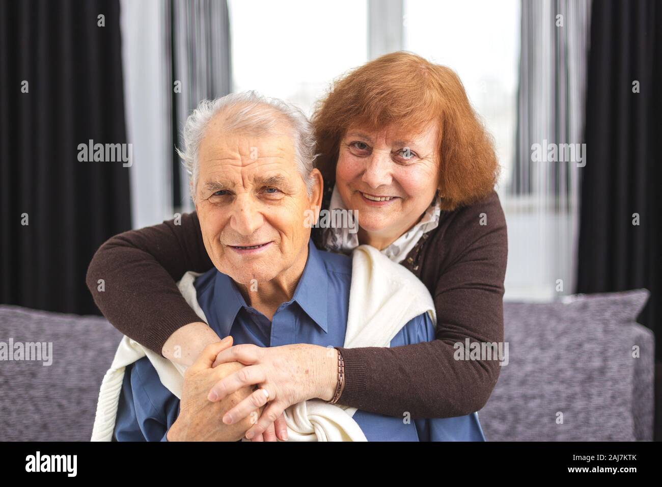 Old Woman Hugs Her Husband Romantic Senior Couple Hugging On Sofa