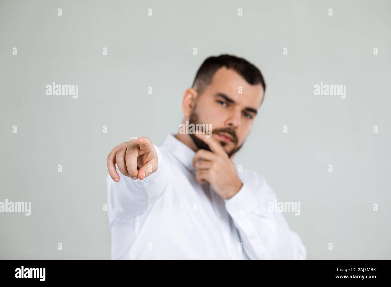 Point Hand Guy handsome young man points hand at you on gray background. focus on hand ...