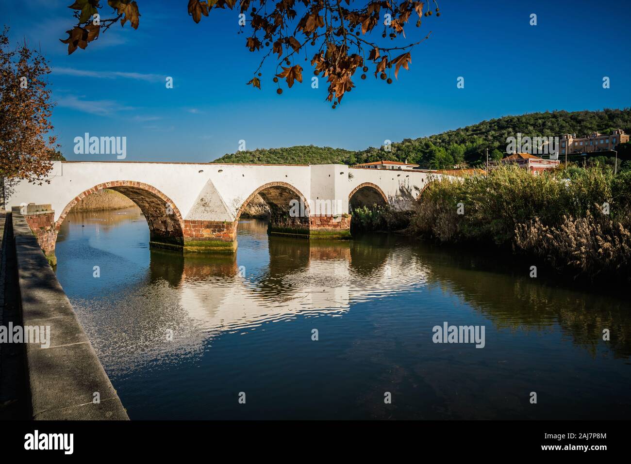 Sunlight and reflections of the Ancient Roman bridge over the River Arade in Silves, Algarve Portugal. Photograph: Tony Taylor Stock Photo