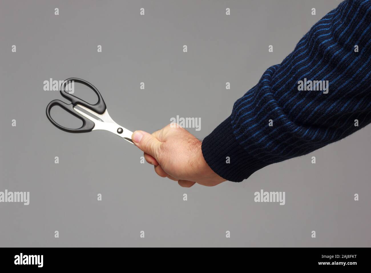 Large professional scissors in a person's hand, prepared to cut or trim