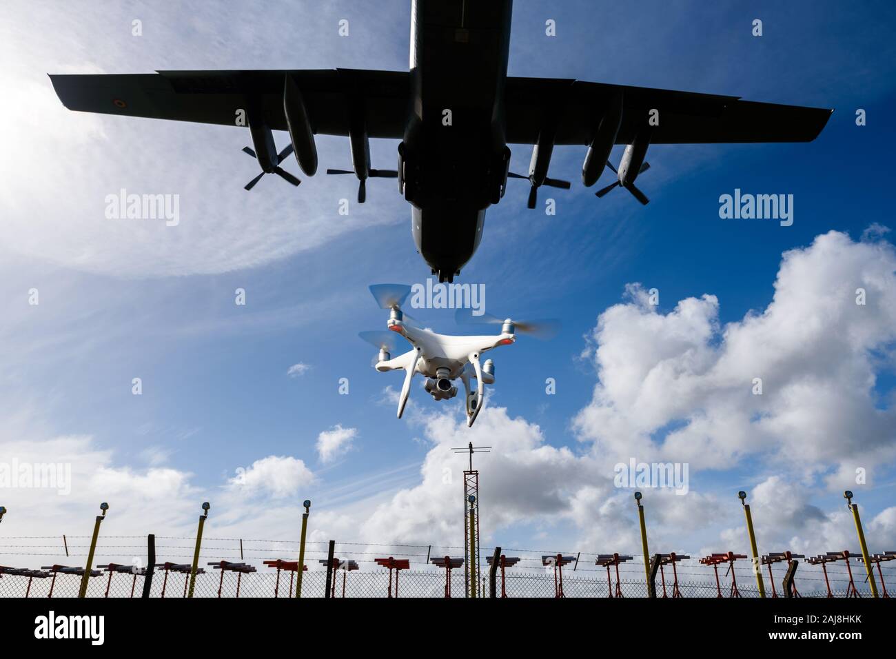 Unmanned drone flying near  commercial airplanes landing at airport, flight disruption concept - digital composite Stock Photo