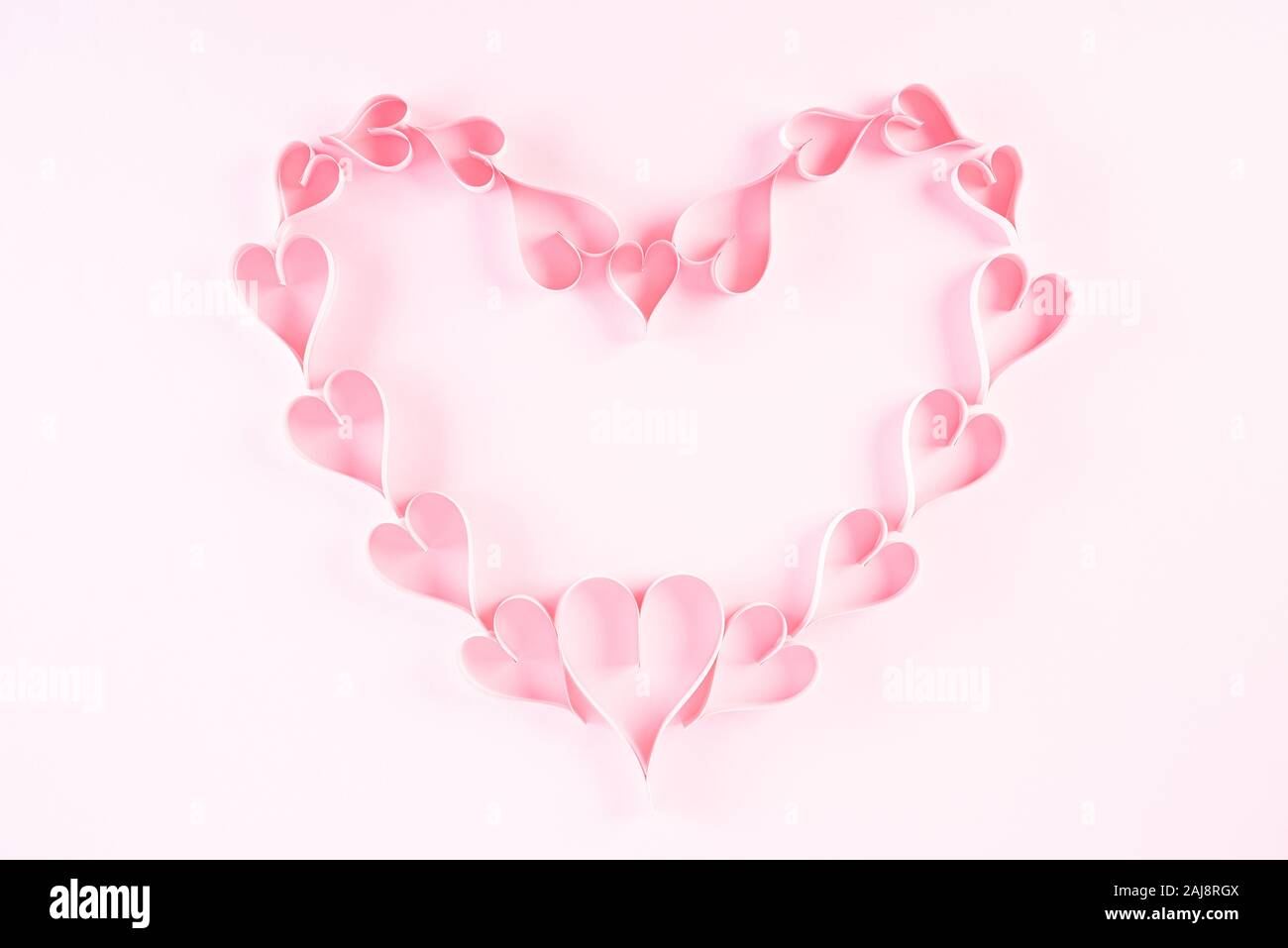 Small Pink paper hearts in shape of heart on Light pink pastel paper  background. Love and Valentine's day concept Stock Photo - Alamy