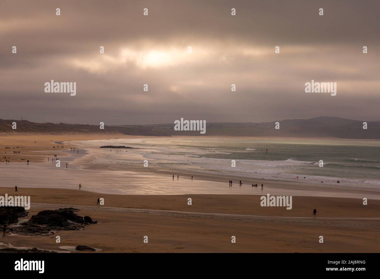 Godrevy Beach in Cornwall England during early evening, with holiday makers and surfers. Stock Photo