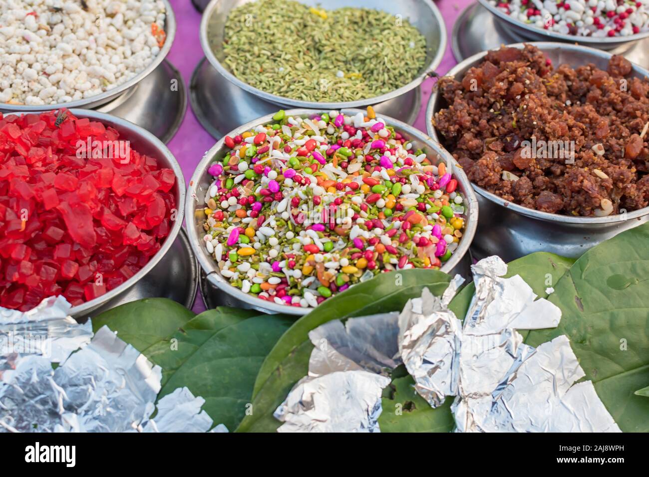 Different types of colorful garnish pan masala used to decorate betel leaf banarasi paan with selective focus Stock Photo