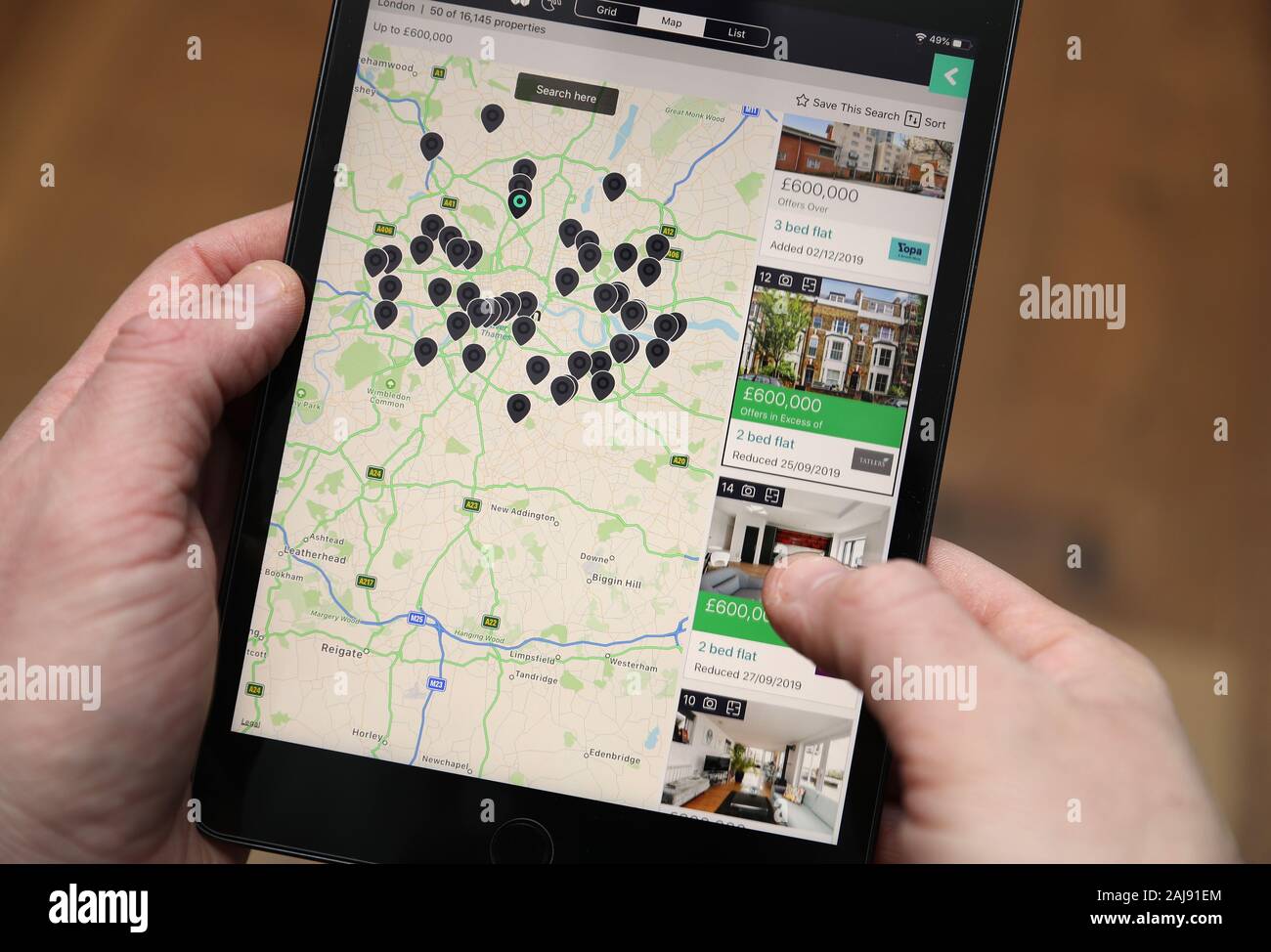 A person looks for properties for sale on the Rightmove app on an iPad  mini. PA