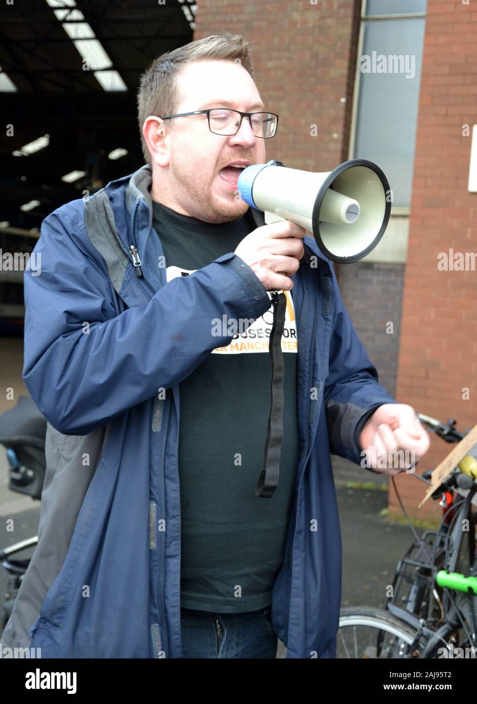 Andrew Gwynne, Labour MP for Denton and Reddish in Greater Manchester and Shadow Secretary of State for Communities and Local Government, speaking to a group of some 25 protesters demanding better bus services which marched through Manchester, United Kingdom, on January 3, 2020. The group marched from the Stagecoach bus depot in Ardwick to the office of the Mayor of Greater Manchester, Andy Burnham, on Oxford Road, to hand in a petition of 11,510 signatures. The protesters called for bus services to be brought back into public control. Stock Photo