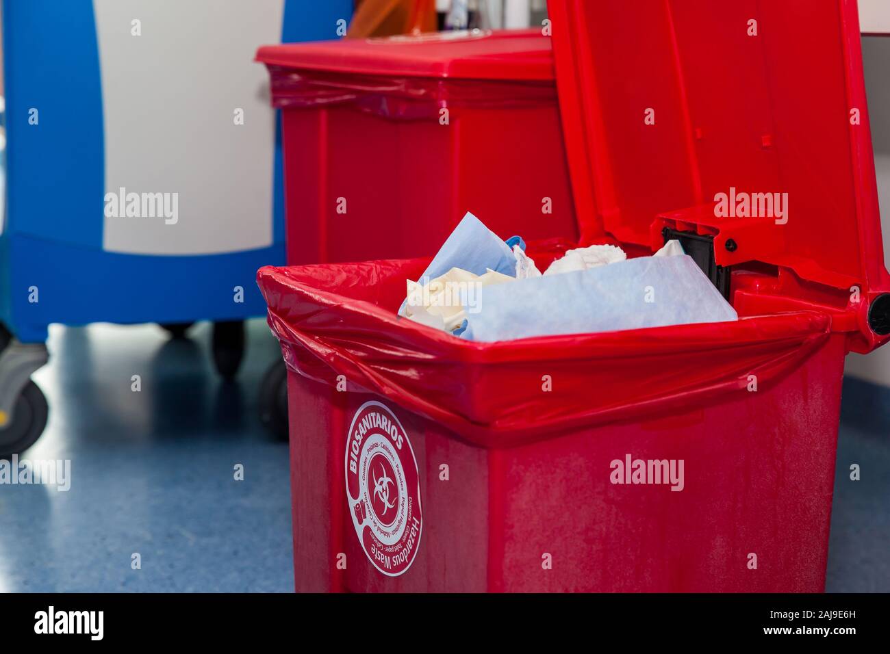 Biological risk waste disposed of in the red trash bag at a operating room in a hospital. Sign showing the biological hazard symbol and the types of w Stock Photo
