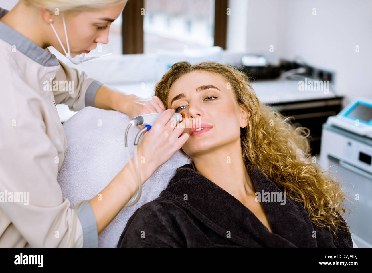 Face Skin Care. Professional female cosmetologist doing hydrafacial