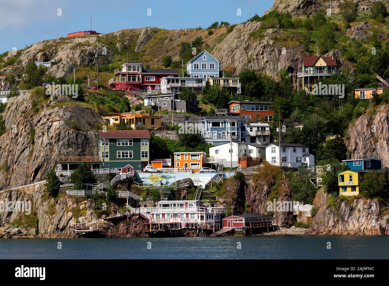 Houses overlook the harbour at St John's, Newfoundland and Labrador, Canada. The flowers are blooming in summertime. Stock Photo