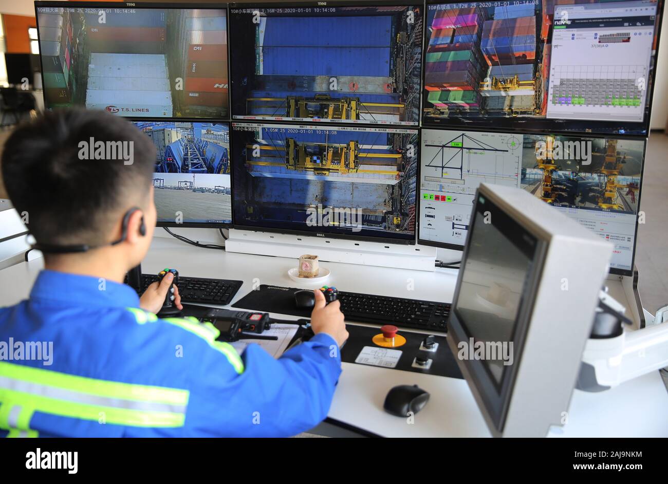A Chinese worker remotecontrols a crane to lift a container from an