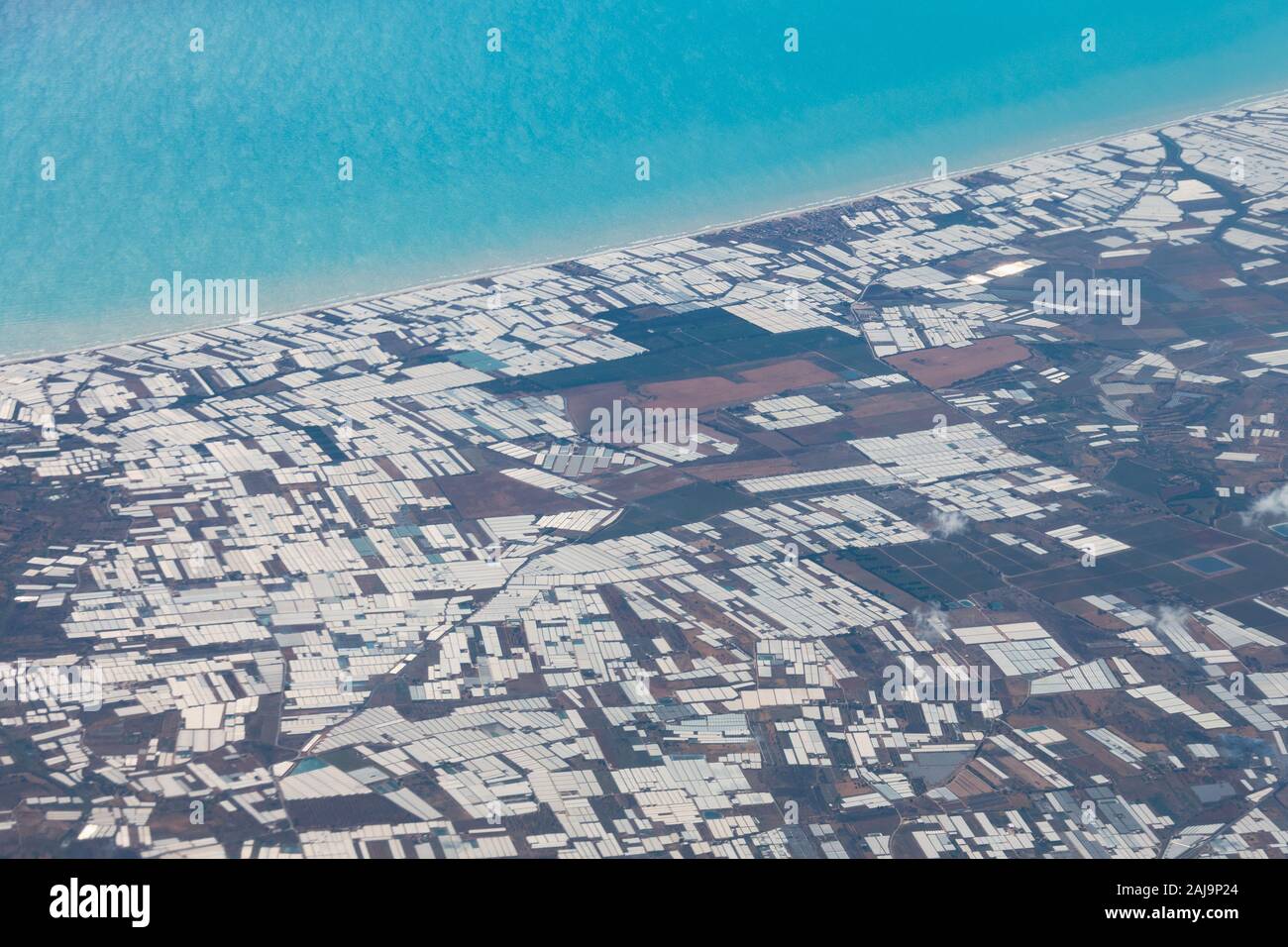 A huge number of greenhouse complexes on the coast, aerial view Stock Photo
