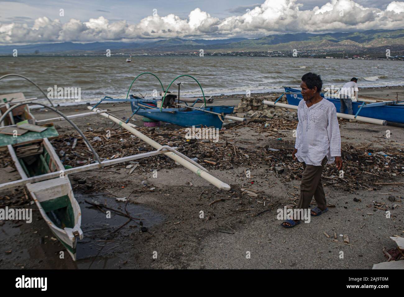 Palu City, Central Sulawesi, Indonesia. 3rd Jan, 2020. A fisherman walks passed an anchored boat.High waves in the waters of Palu Bay forced Hundreds of fishermen in the village of Lere to anchor their boats. According to the Palu Meteorology, Climatology and Geophysics Agency (BMKG) the waves reached two meters to three meters, considered quite dangerous for fishermen. Credit: Opan Bustan/SOPA Images/ZUMA Wire/Alamy Live News Stock Photo