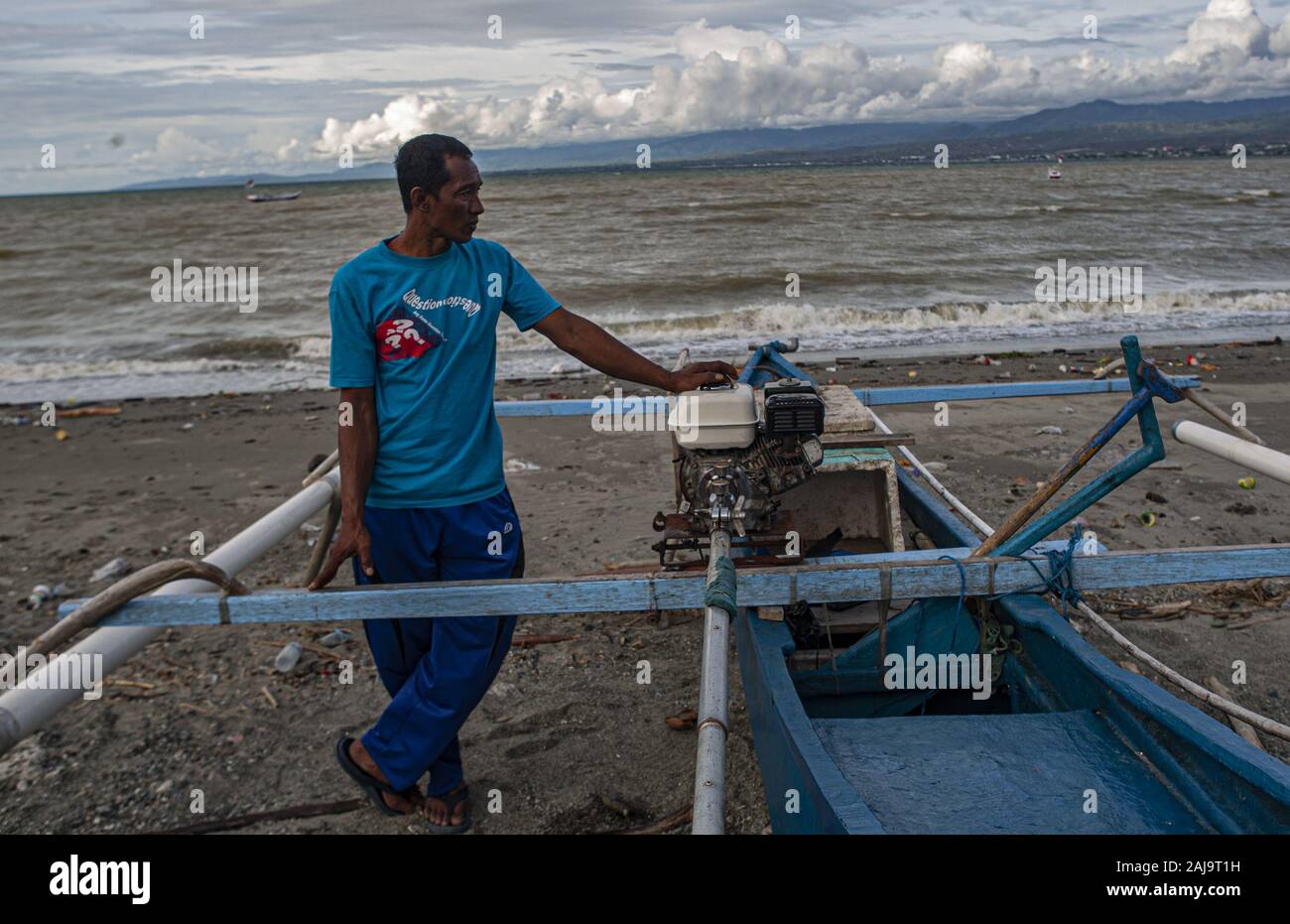Palu City, Central Sulawesi, Indonesia. 3rd Jan, 2020. A fisherman poses next to his boat.High waves in the waters of Palu Bay forced Hundreds of fishermen in the village of Lere to anchor their boats. According to the Palu Meteorology, Climatology and Geophysics Agency (BMKG) the waves reached two meters to three meters, considered quite dangerous for fishermen. Credit: Opan Bustan/SOPA Images/ZUMA Wire/Alamy Live News Stock Photo