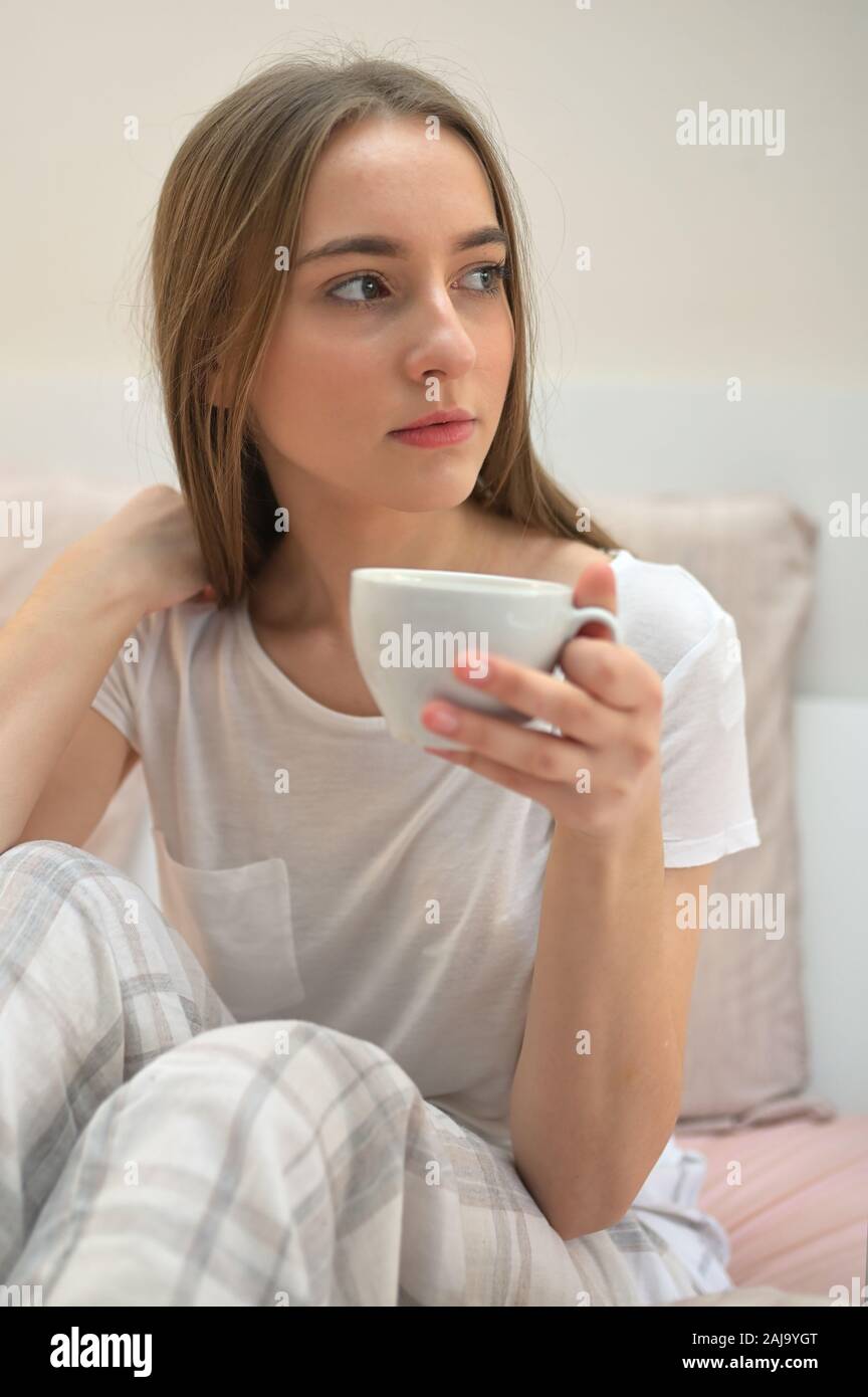 Girl With Cup Of Coffee In The Bedroom Stock Photo