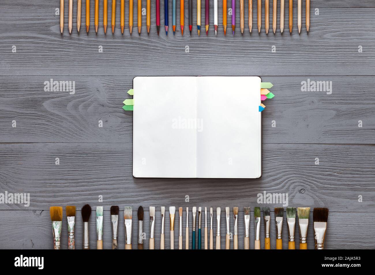 Creative art table concept, blank notebook sketchbook on grey wooden background Stock Photo