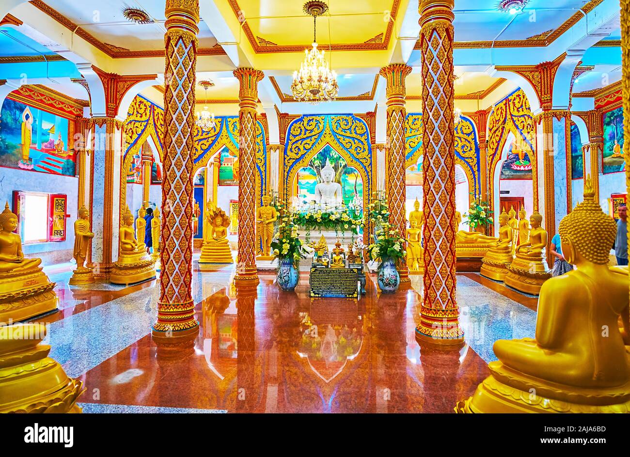 CHALONG, THAILAND - APRIL 30, 2019: The prayer hall of Wat Chalong Pagoda is decorated with scenic columns, murals, depicting life of Buddha, gilt ima Stock Photo