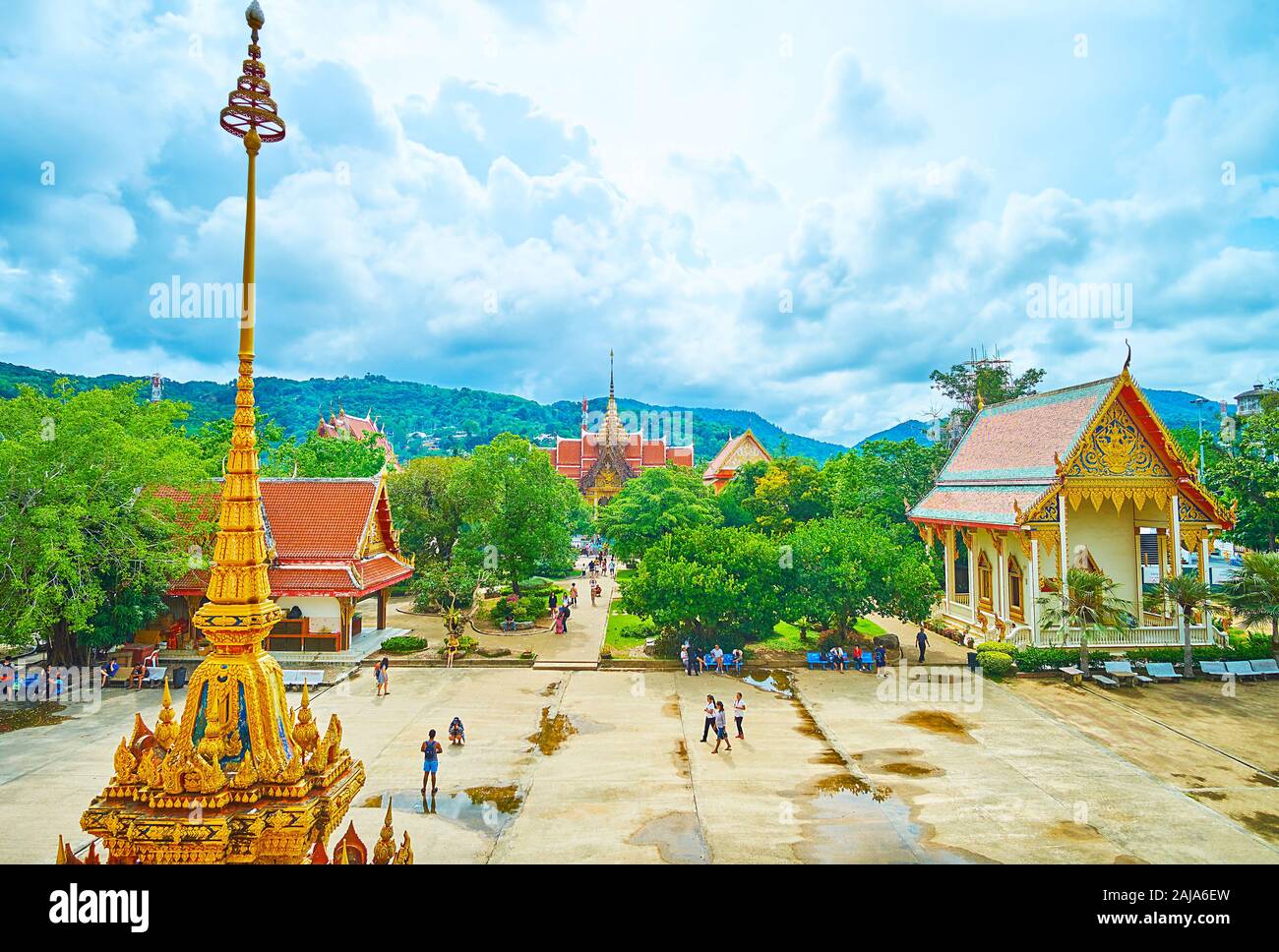 CHALONG, THAILAND - APRIL 30, 2019: The shrines on the grounds of Wat Chalong temple complex with a view on the spire and finial of the chedi on the f Stock Photo