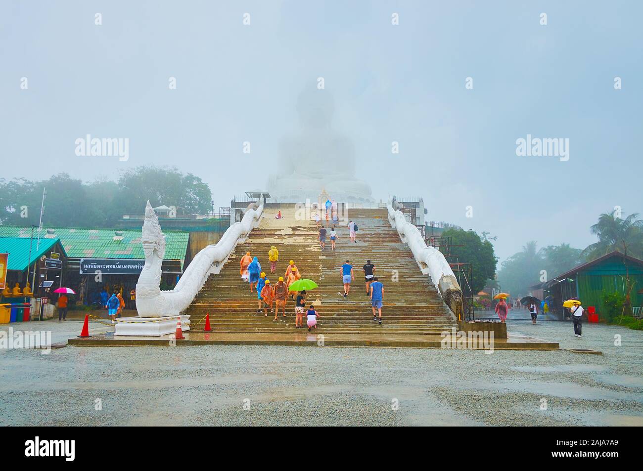 CHALONG, THAILAND - APRIL 30, 2019: The view on Great Buddha of Phuket (Ming Mongkol Buddha) in the hard rain - the image is hardly seen through the r Stock Photo
