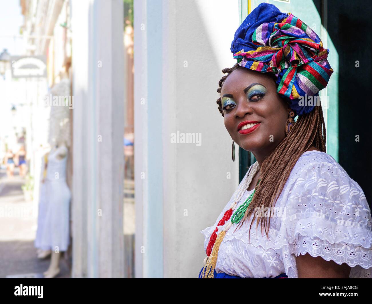 Happy Brazilian woman of African descent dressed in traditional Baiana costumes in the Historic Center of Salvador da Bahia, Brazil. Stock Photo