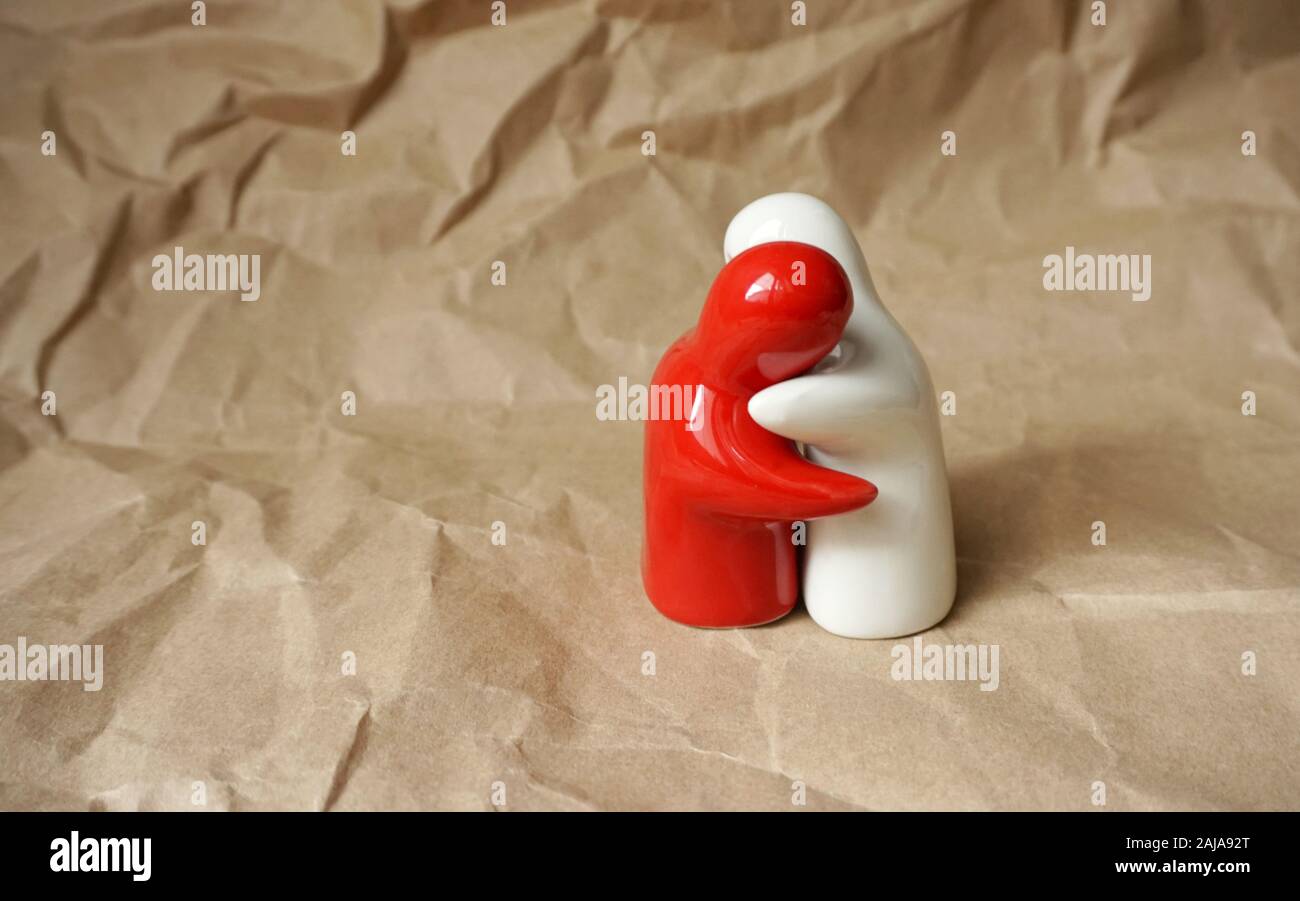 Conceptual background. A symbolic representation of hugged people on the background of natural paper and free copy space Stock Photo