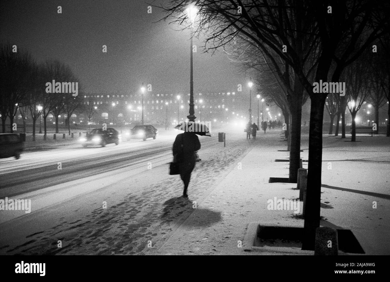 PARIS WINTER - PEDESTRIANS FIGHTING AGAIN A STRONG SNOW SHOWER - LEICA NIGHT STREET PHOTOGRAPHY - PARIS STREET PHOTOGRAPHY - SILVER FILM © Frédéric BEAUMONT Stock Photo