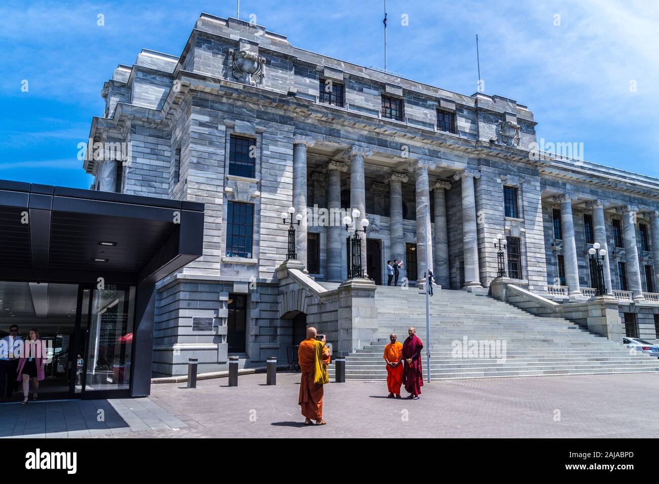 Buddhist monks taking selfie photographs on the steps of Parliament House, Wellington, New Zealand Stock Photo