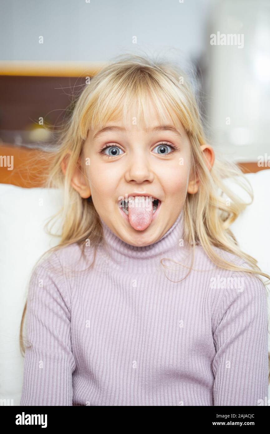 Cute little girl sticking out her tongue Stock Photo - Alamy