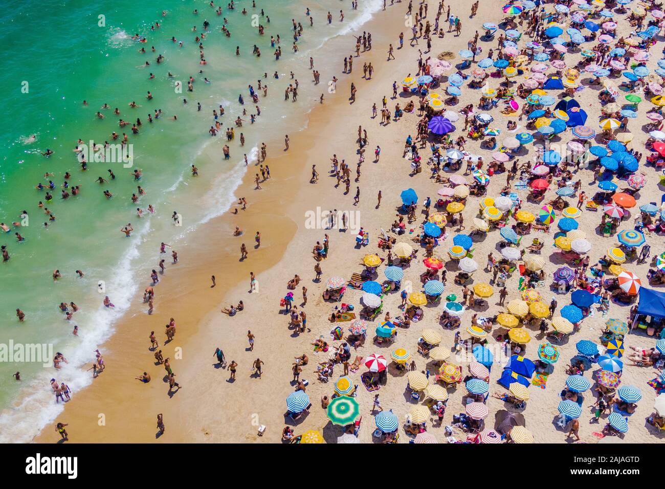 Rio de Janeiro, Brazil, aerial view of Copacabana Beach showing colourful umbrellas and people bathing in the ocean on a summer day. Stock Photo