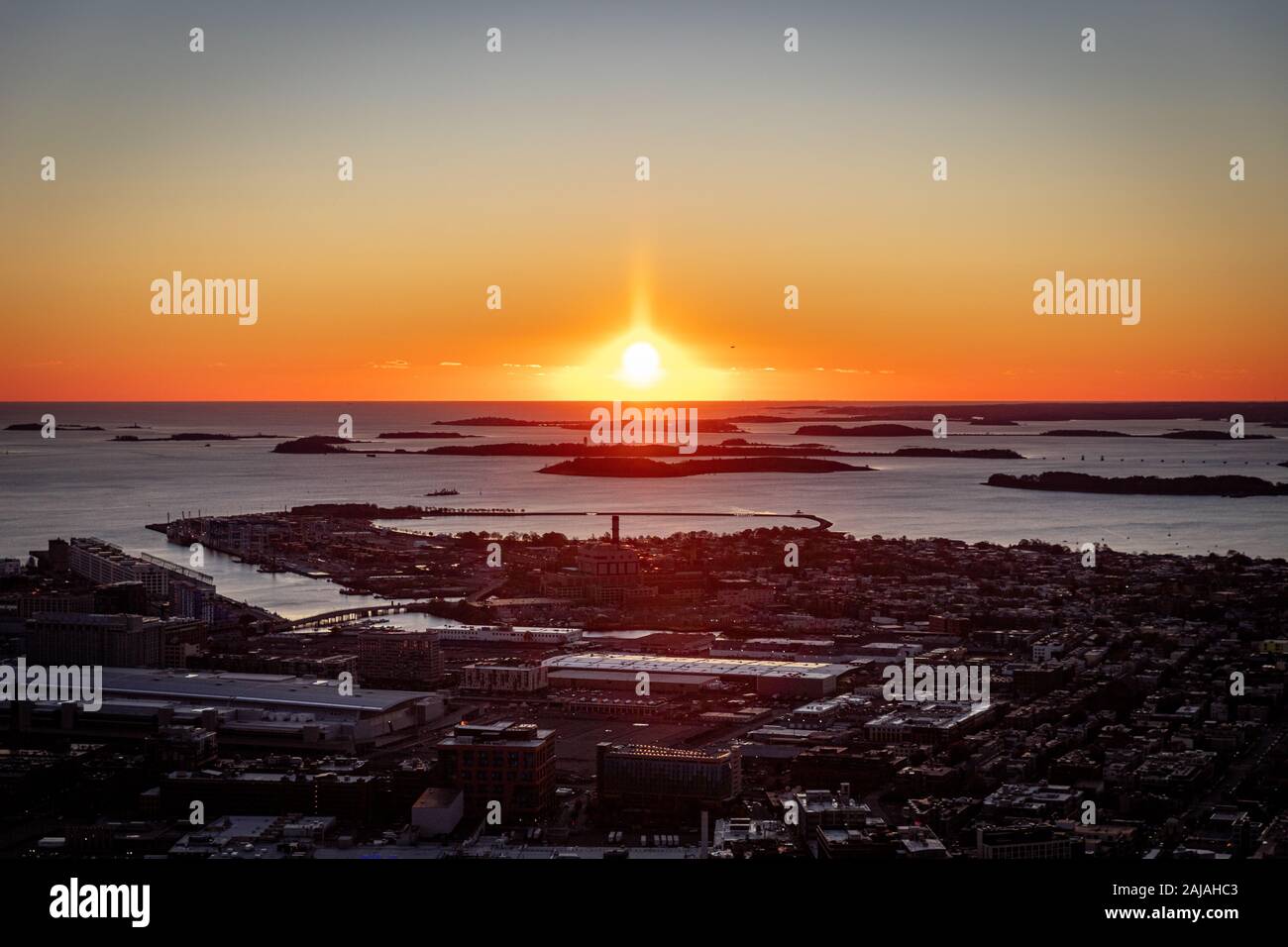Sun rising over horizon beyond islands outside of Boston. Stock Photo