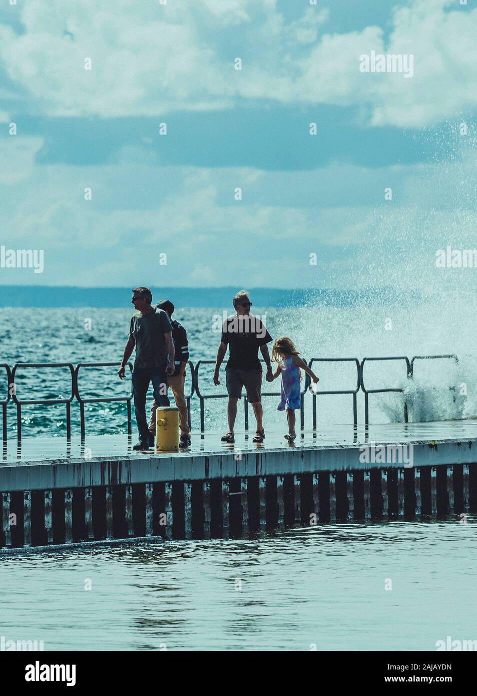 Group of people walking on a pier during the storm Stock Photo