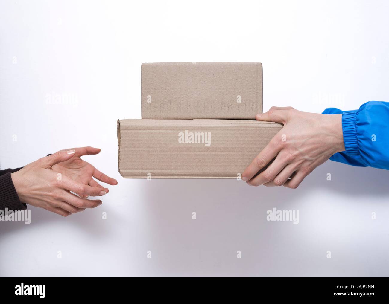 The courier gives delivery boxes to the customer. Stock Photo