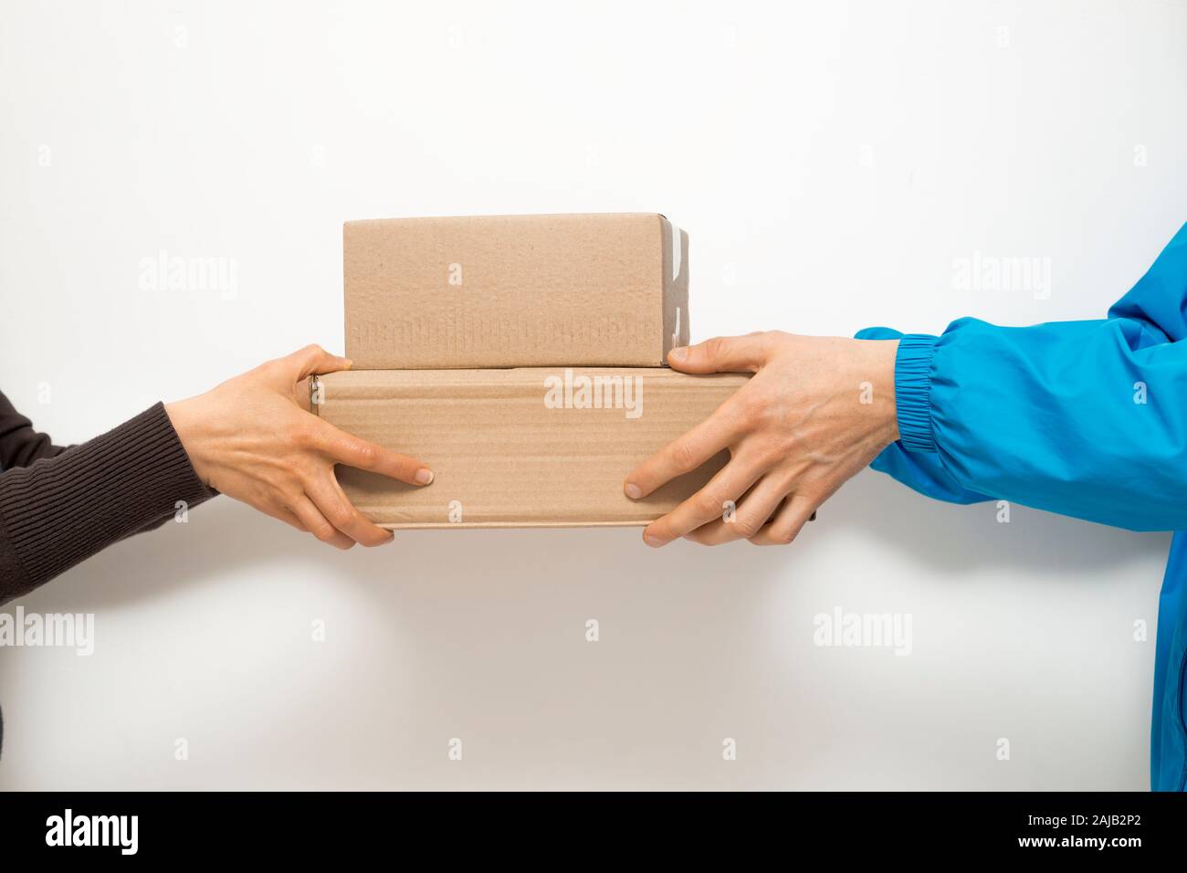 The courier gives delivery boxes to the customer. Stock Photo